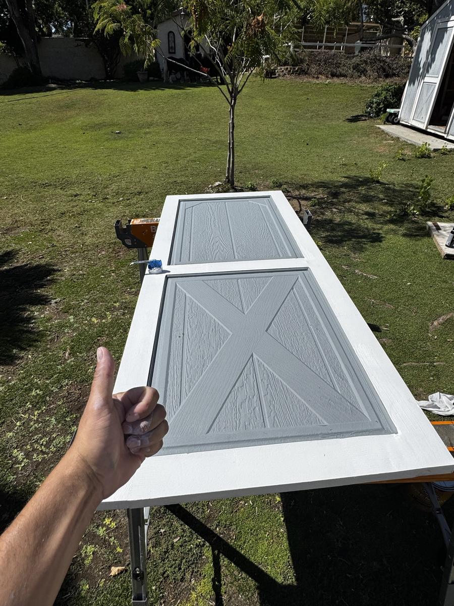 Shed door freshly painted white and gray