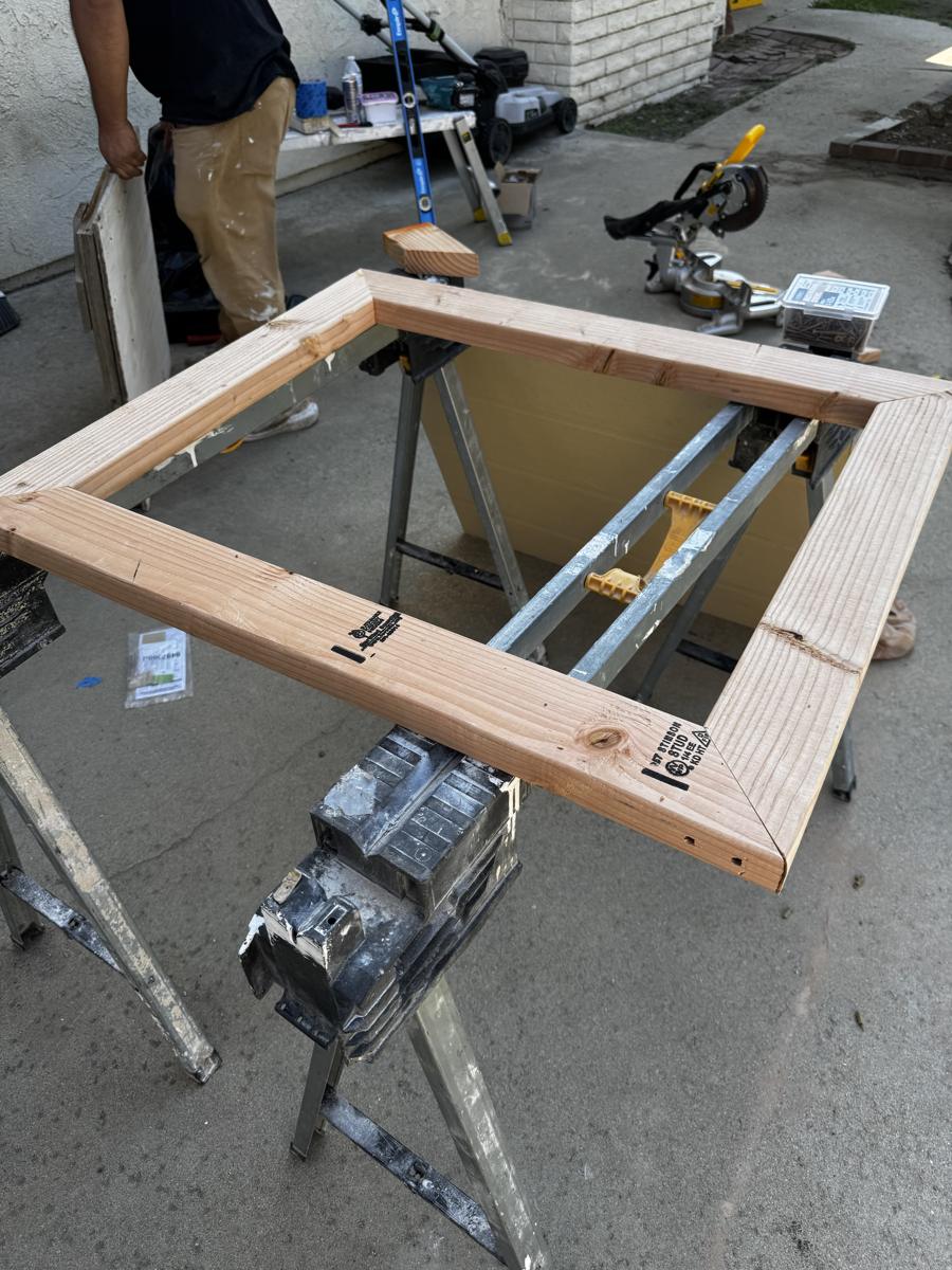 Mitered wood frame being built on sawhorses