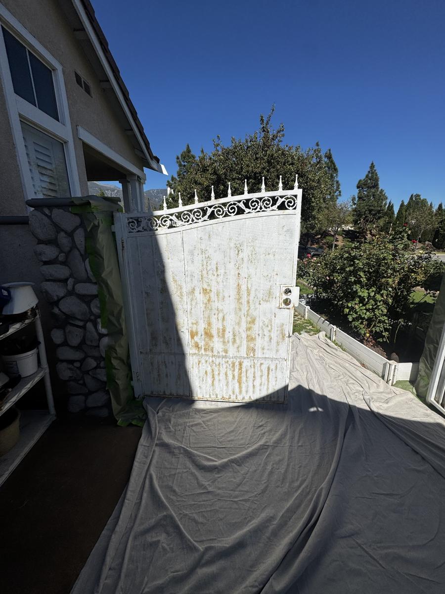 Wrought iron gate before repainting, rusted and peeling
