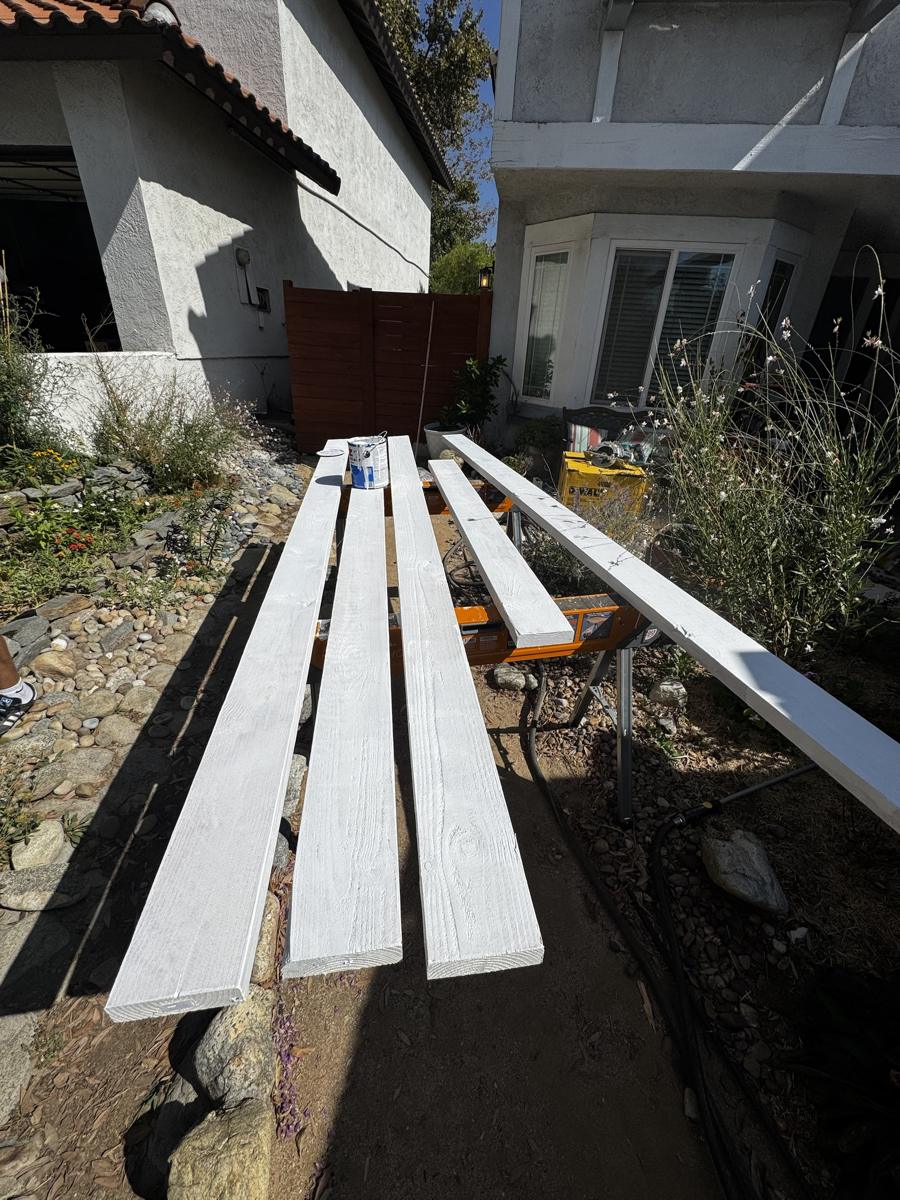 New trim boards primed white on sawhorses